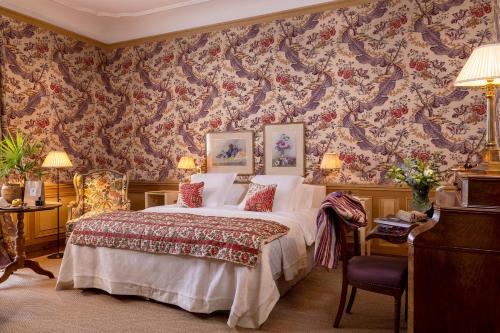a bedroom with a bed with a floral wallpaper at La Mirande in Avignon