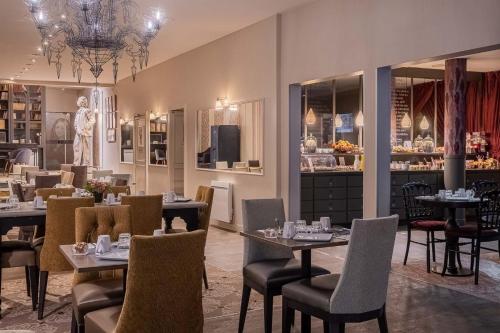 a dining room with tables and chairs and a store at Hôtel Littéraire Gustave Flaubert, BW Signature Collection in Rouen