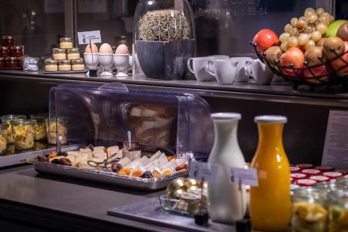 a buffet with a tray of food on a table at Hôtel Littéraire Gustave Flaubert, BW Signature Collection in Rouen