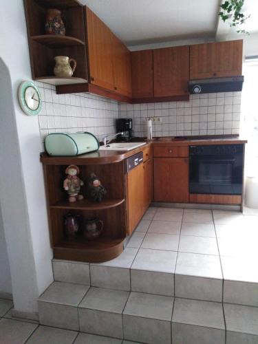a kitchen with wooden cabinets and a sink at Landhaus Wohnung in D 63667 Nidda, Gäßchen 8 Erdgeschoss rechts in Nidda