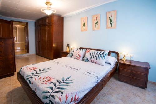 een slaapkamer met een bed en een houten dressoir bij Rosabelas in Alcanar