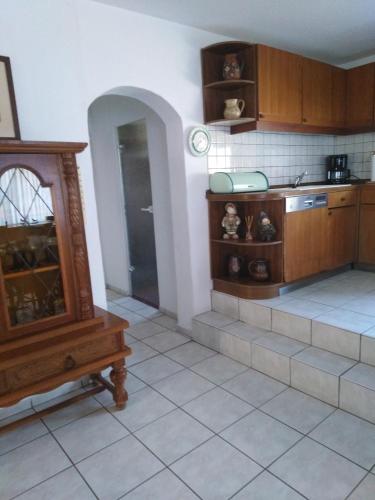 a kitchen with wooden cabinets and a tiled floor at Landhaus Wohnung in D 63667 Nidda, Gäßchen 8 Erdgeschoss rechts in Nidda