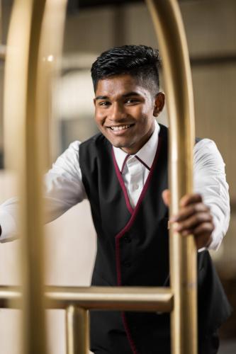 a man in a vest and tie is smiling at Elaf Al Taqwa Hotel in Al Madinah