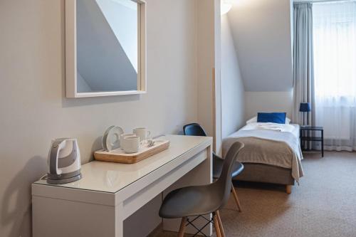 a room with a white desk with a chair and a bed at Gronie Ski & Bike in Szczyrk