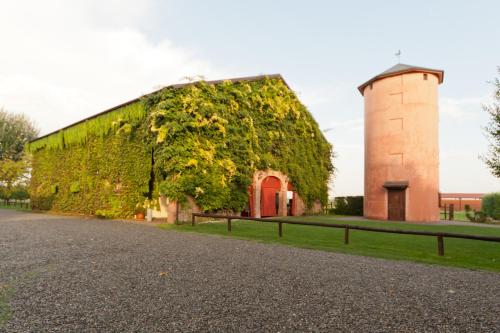 a building covered in ivy next to a tower at Agriturismo La Lupa in Madonna della Provvidenza