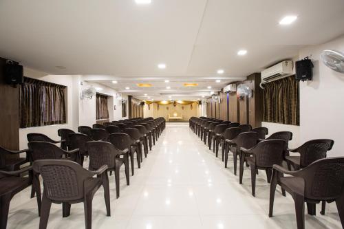a row of chairs in a room with white floors at Santhoshpuri in Coimbatore