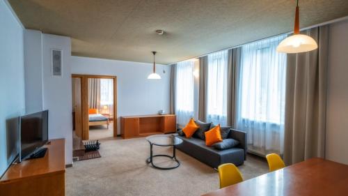 a living room with a couch and a television at Gronie Ski & Bike in Szczyrk