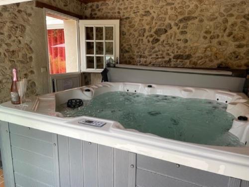 a bath tub filled with water in a bathroom at SUITE ROMANTIQUe in Cléré-les-Pins