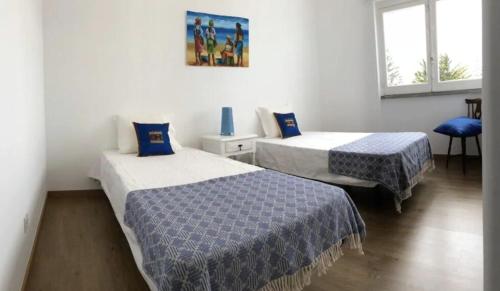 ein Hotelzimmer mit 2 Betten und einem Fenster in der Unterkunft Casal de São José - Praia das Maçãs in Colares