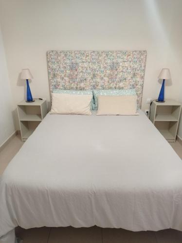 a bedroom with a large white bed with two lamps at Cañete 4 in La Laguna