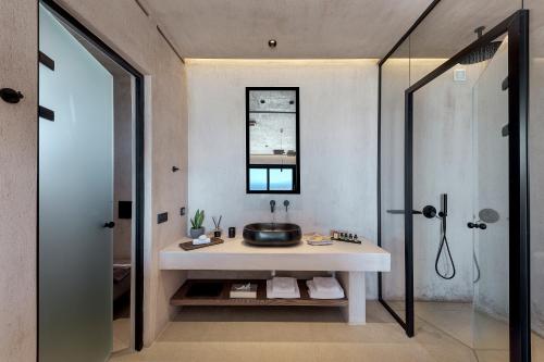 a bathroom with a sink and a shower at North Santorini - A Luxury Spa Hotel in Pirgos