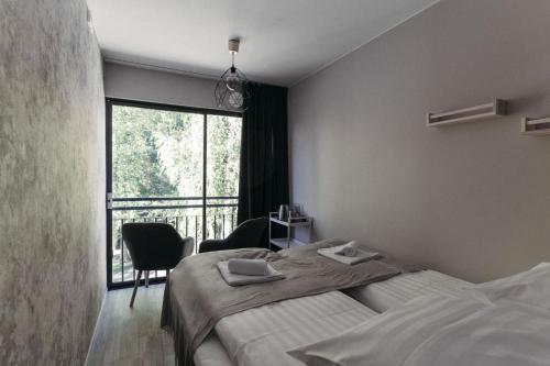 a bedroom with two beds and a large window at Hotel Mathildedal in Matildedal
