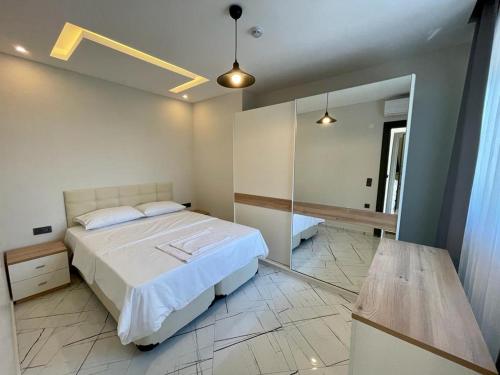 a bedroom with a large bed and a mirror at LOTUS Apart in Kuşadası