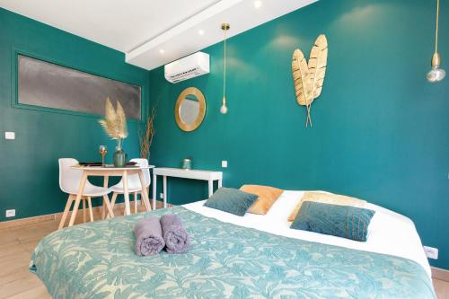 Un dormitorio con una cama con paredes azules y una mesa. en Love Suite and SPA - CANNES en Cannes