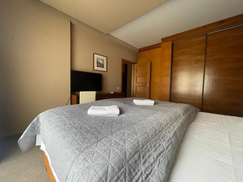 um quarto com uma cama grande com duas toalhas em Willa Port 110 em Ostróda
