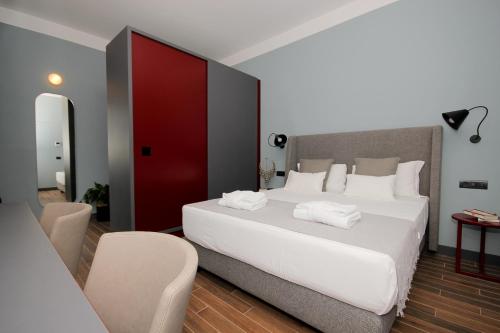 a bedroom with a large white bed and a red door at Augusto Imperial Apartment and Suites - Castel Sant'Angelo in Rome