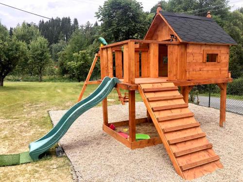 a wooden play house with a slide and a slope at Chalupa Lilien pod Medvědí skálou Jeseníky in Jindřichov