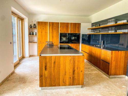a kitchen with wooden cabinets and a counter top at Ferienvilla Joachimsberg mit Swimspa und Sauna in Wienerbruck