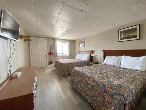 a hotel room with two beds and a tv at Island View Motel in Old Orchard Beach