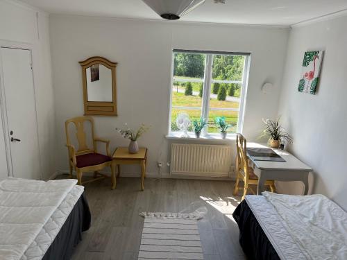 a bedroom with a bed and a desk and a window at Annexet Kilafors in Kilafors