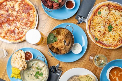 una mesa llena de platos de comida con pizza en Holiday Inn Express Aberdeen City Centre, an IHG Hotel, en Aberdeen