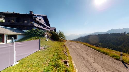 a dirt road with a fence next to a house at Beautiful apartment for 4 people with a splendid view of les Dents du Midi in Champoussin