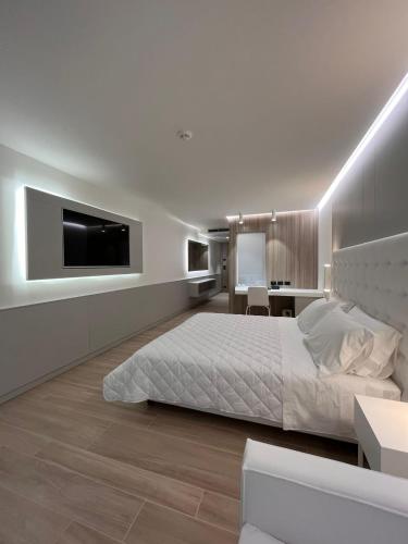 a bedroom with a bed and a tv on a wall at Hotel Columbus in Lignano Sabbiadoro