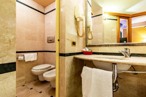 a bathroom with a toilet and a sink and a mirror at Hotel Motel Miami in Limito di Pioltello