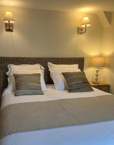 a bedroom with a large bed with two pillows at Hotel l'Avenue in Chantilly