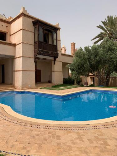 una gran piscina azul frente a una casa en Villa Fairview- 8 Bedrooms Villa in Agadir, en Agadir