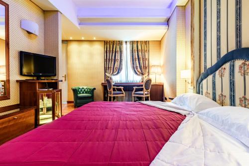 ein Hotelzimmer mit einem großen Bett und einem TV in der Unterkunft Hotel Motel Miami in Limito di Pioltello