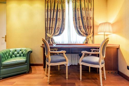 a room with a table and two chairs and a window at Hotel Motel Miami in Limito di Pioltello