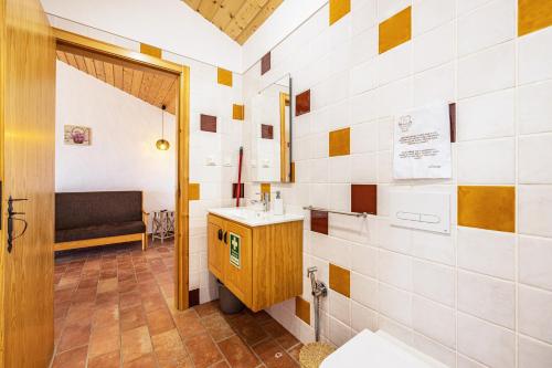 a bathroom with a sink and a bench in a room at Monte do Tanoeiro - Casa Nova in Rogil