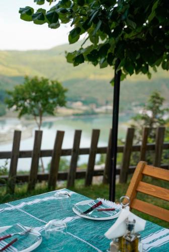 a picnic table with a view of a lake at Bujtina Adora in Ara të Lumit