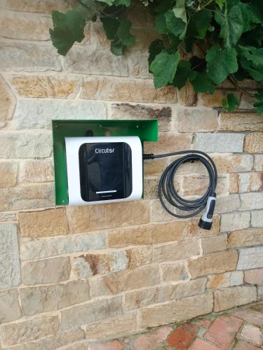 a television attached to a brick wall with a hose at Posada La Fabula in Santillana del Mar
