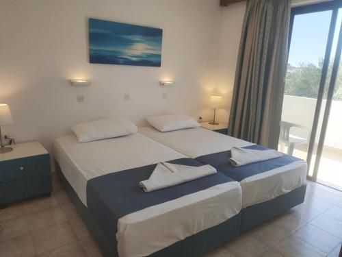 アルハンゲロスにあるHotel Narkissosのベッドルーム1室(ベッド2台、大きな窓付)