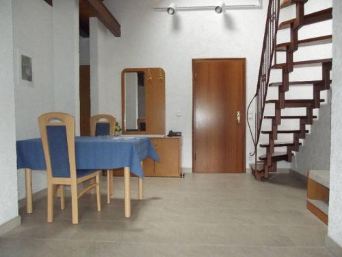 un tavolo blu e sedie in una stanza con scale di Ferienwohnung Bauer a Bad Herrenalb