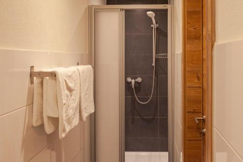 a bathroom with a shower with a glass door at Berghotel TheLounge in Berwang