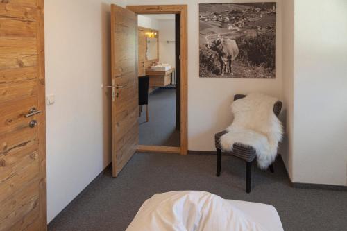 a room with a mirror and a chair at Berghotel TheLounge in Berwang