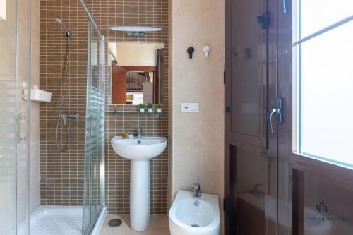uma casa de banho com um lavatório, um chuveiro e um WC. em Living4Malaga La Dolce Vita Duplex em Málaga