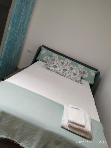 uma cama com uma almofada e uma toalha em B&B SA CROBE em Lanusei