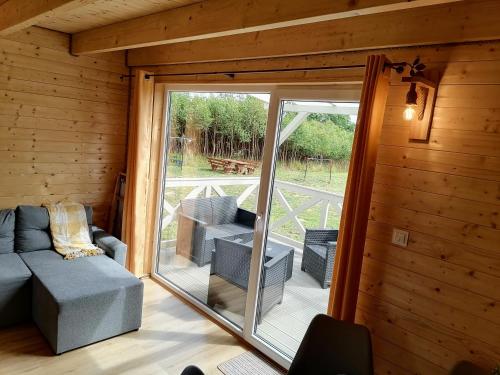 a living room with a couch and a sliding glass door at Brzozowa Polana in Perlino