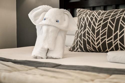 a white elephant stuffed animal sitting on a bed at Indaba Hotel, Spa & Conference Center in Johannesburg