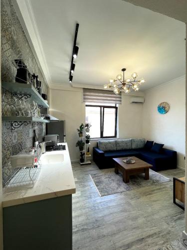 a living room with a blue couch and a table at Style Home Buzovna in Baku