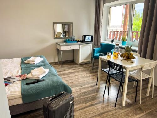 een hotelkamer met een bed, een tafel en een bureau bij Willa Sonata - Apartamenty & Balia - Szklarska Poręba in Szklarska Poręba
