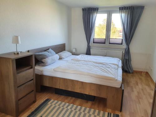 Un dormitorio con una cama grande y una ventana en FEWODAYs Ferienwohnung in Sassnitz - Ruegen, en Sassnitz