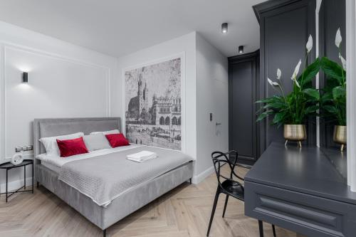 um quarto com uma cama com almofadas vermelhas e uma secretária em Apartament w centrum Krakowa 109 em Cracóvia
