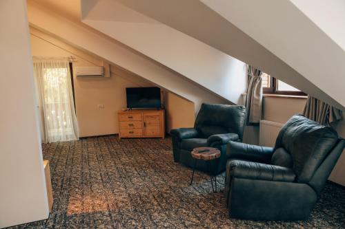 a living room with two chairs and a television at Popasul Domnesc- Resort& Spa- Voronet Vue in Voronet