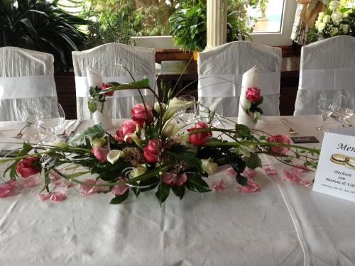 a table with a bouquet of pink flowers on it at Hotel Zum weißen Stein in Kirchen