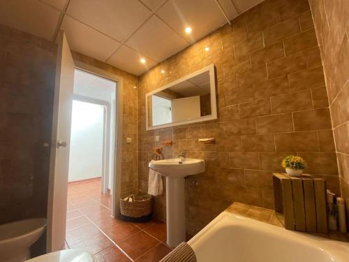 une salle de bain avec une baignoire, un lavabo et un miroir dans l'établissement Vivienda Rural EL CERRO, à Siles